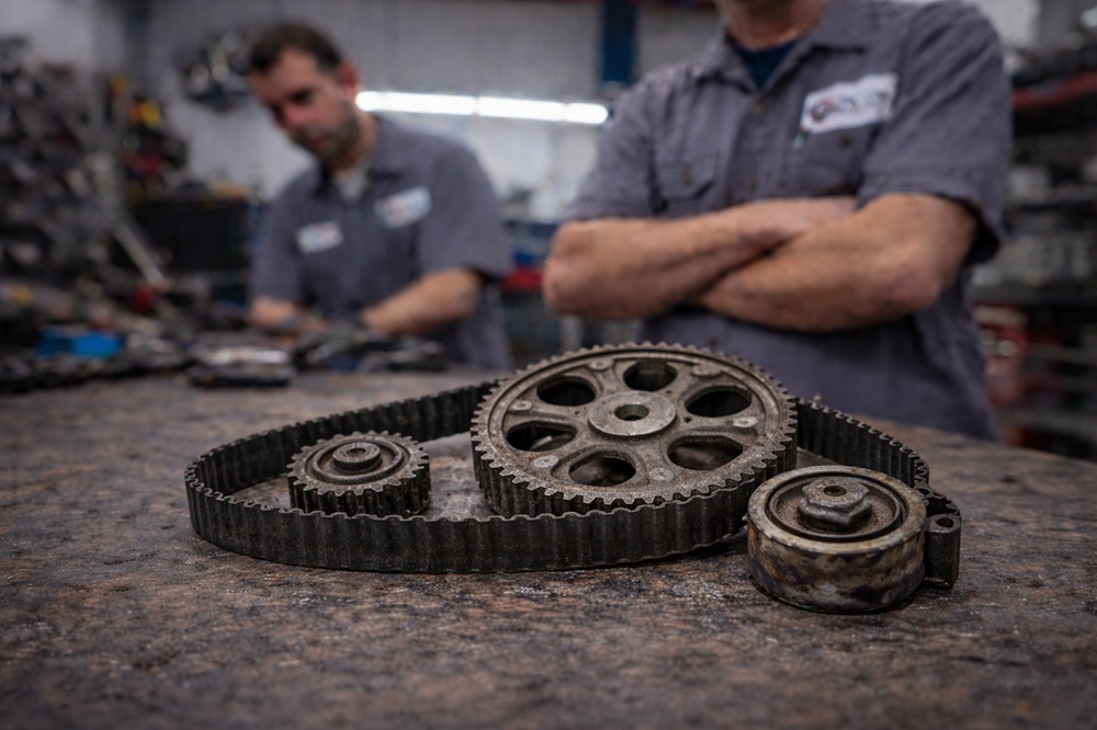 Technician inspecting used engine timing gears
