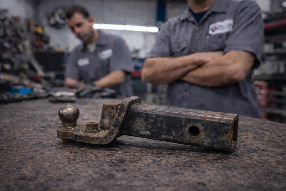 Technician inspecting used trailer hitch receiver